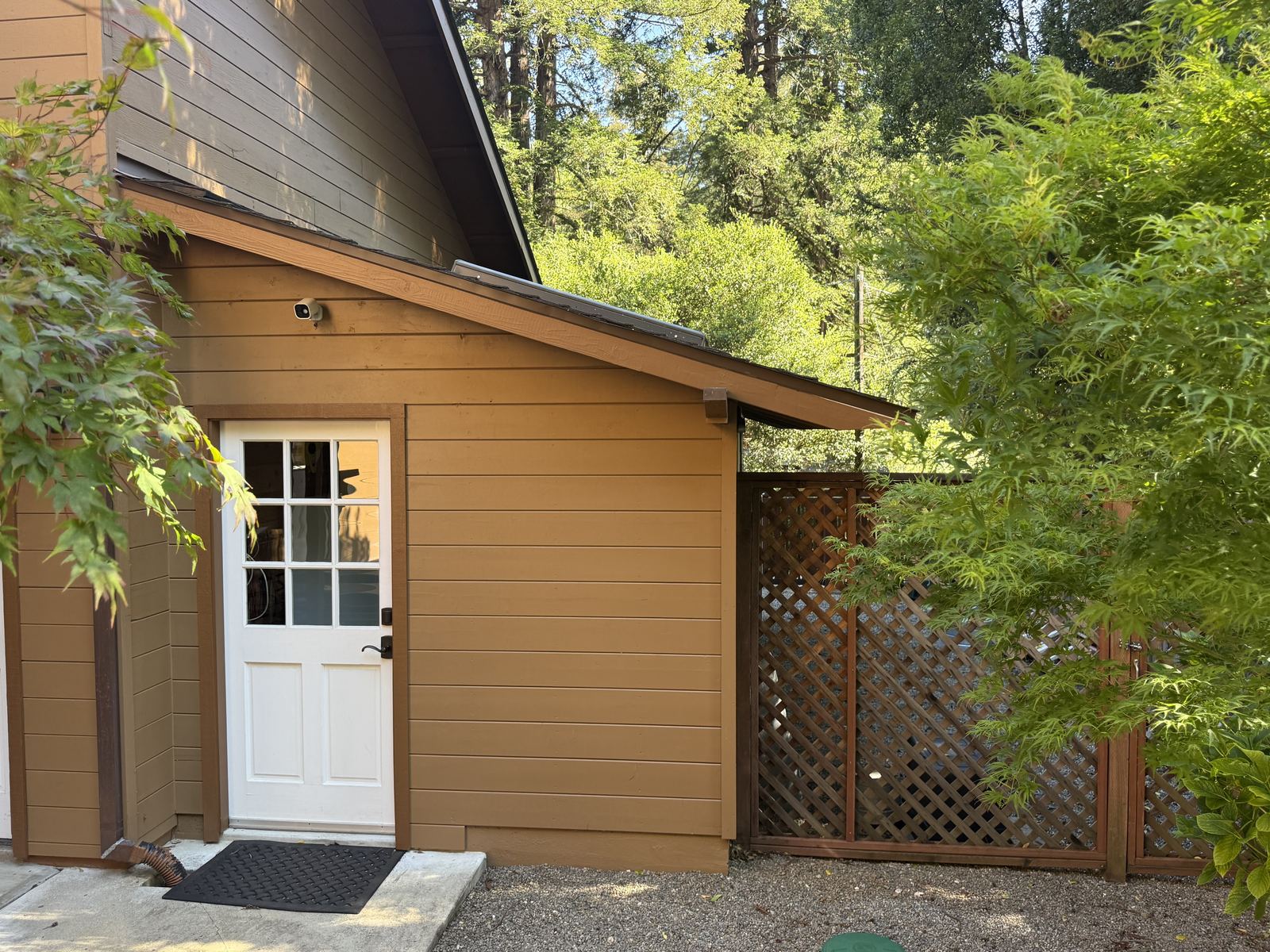 Gravel ground cover with a wood lattice gate attached to the structure