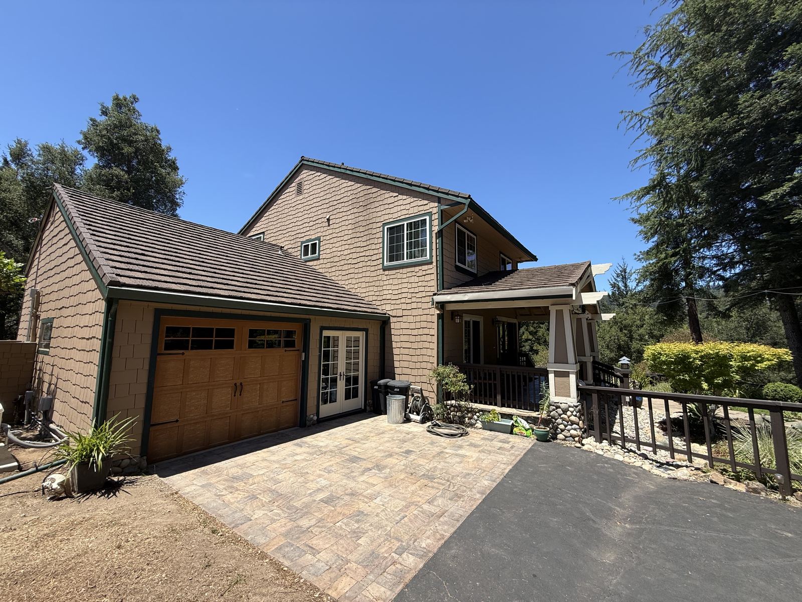 A hardened home with metal shingle roof, fiber cement siding, and stone hardscape