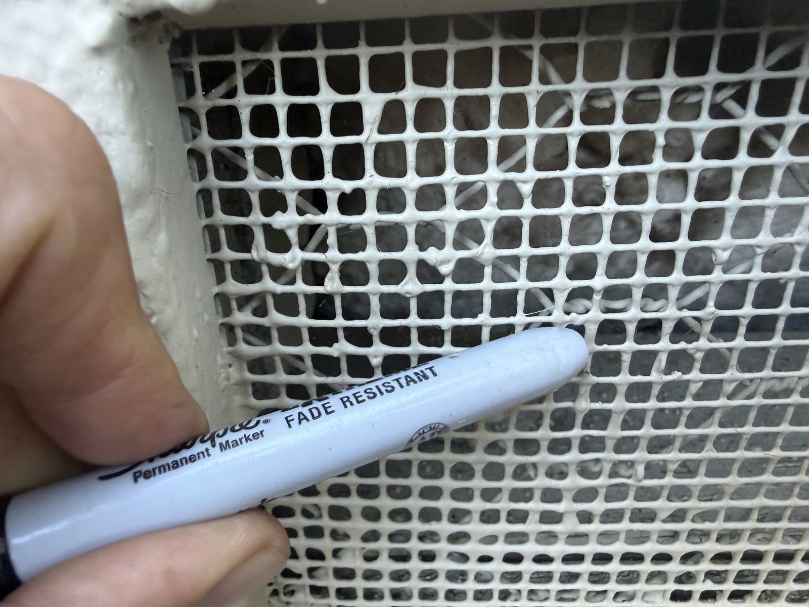 A specialist verifies vent mesh gauge up close during an assessment